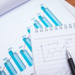 Financial charts with pencil on table